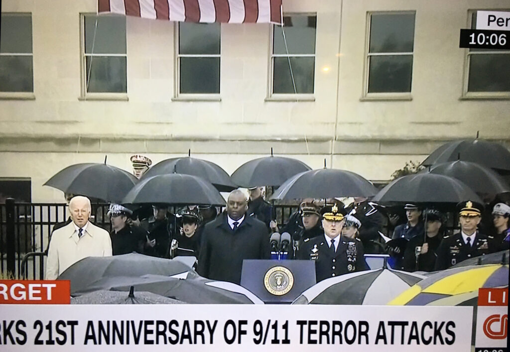 Joe Biden elnök (b), Lloyd Austin védelmi miniszter (k) és Mark Milley vezérkari főnök énekli a nemhivatalos himnuszt. 2022. szeptember 11. (Képernyőfotó)