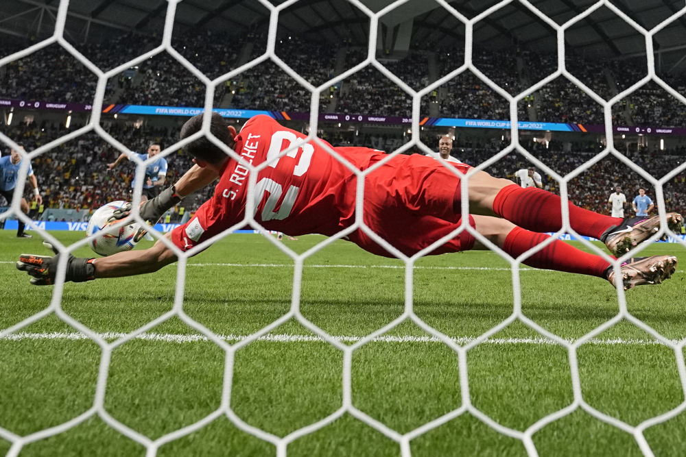Az uruguayi Sergio Rochet a ghánai Andre Ayew tizenegyesét hárítja az Uruguay-Ghána mérkőzésen a Katarban zajló világbajnokság H csoportjának utolsó fordulójában (AP Photo/Manu Fernandez)