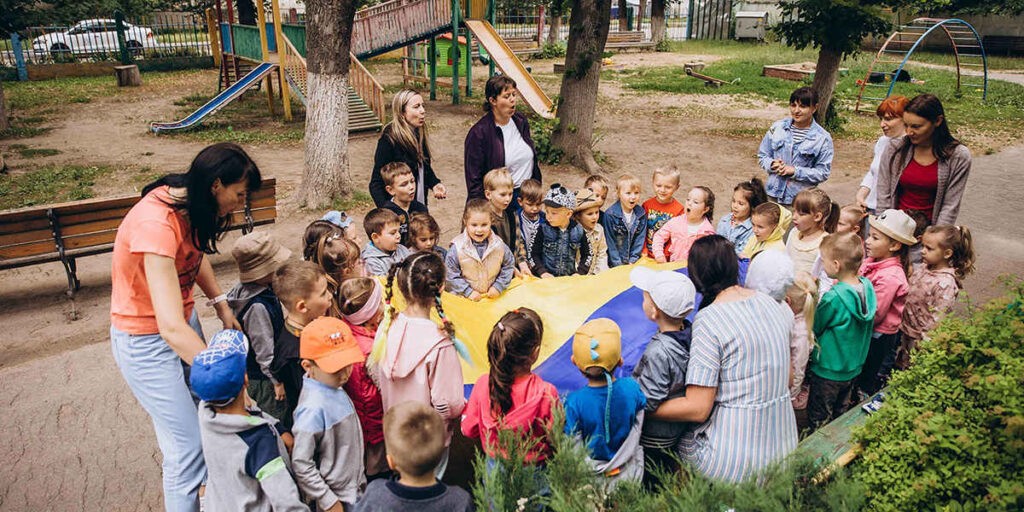 Egy irpinyi óvodában imádkoznak a gyerekek az ukrán zászlóval a békéért 2022 júliusában (Fotó: Shutterstock)