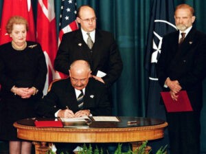 Martonyi János magyar külügyminiszter (ül) letétbe helyezi a NATO-csatlakozási dokumentumot. A háttérben Madeleine Albright amerikai, Jan Kavan cseh és Bronislaw Geremek lengyel külügyminiszter. Independence, Missouri, USA, 1999. március 12. (Fotó: John Rutrof/MTI/EPA)