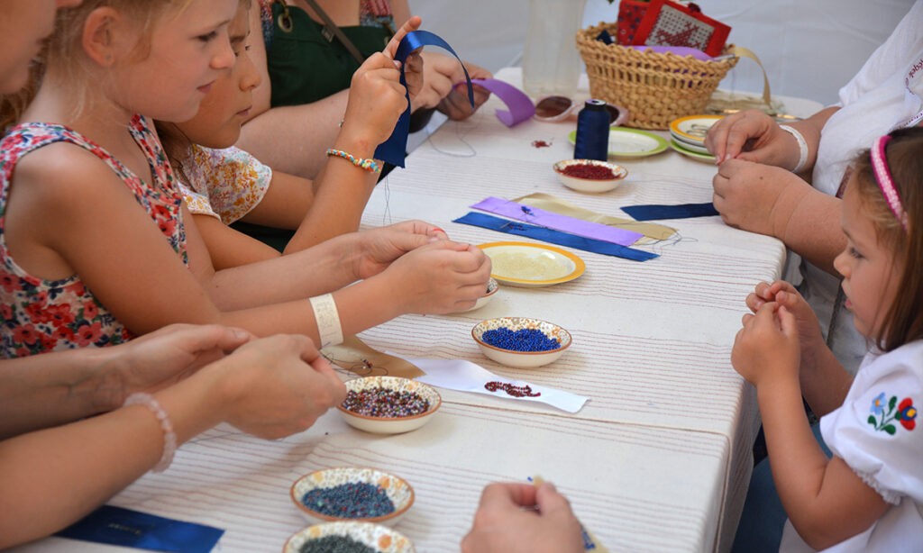 A gyöngyfűzés tudományát adják át az idősebbek a fiataloknak, Mesterségek Ünnepe. Budapest, 2024. augusztus 20. (Fotó: Szappanos Veronika/SZMSZ)