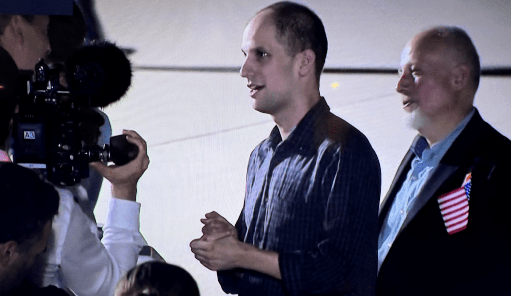 Evan Greshkovich (Wall Street Journal) újságíró kollégáknak nyilatkozik a washingtoni megérkezés után. Mögötte az édesapja. Andrews Légitámaszpont, 2024. augusztus 1. (Képernyőfotó)