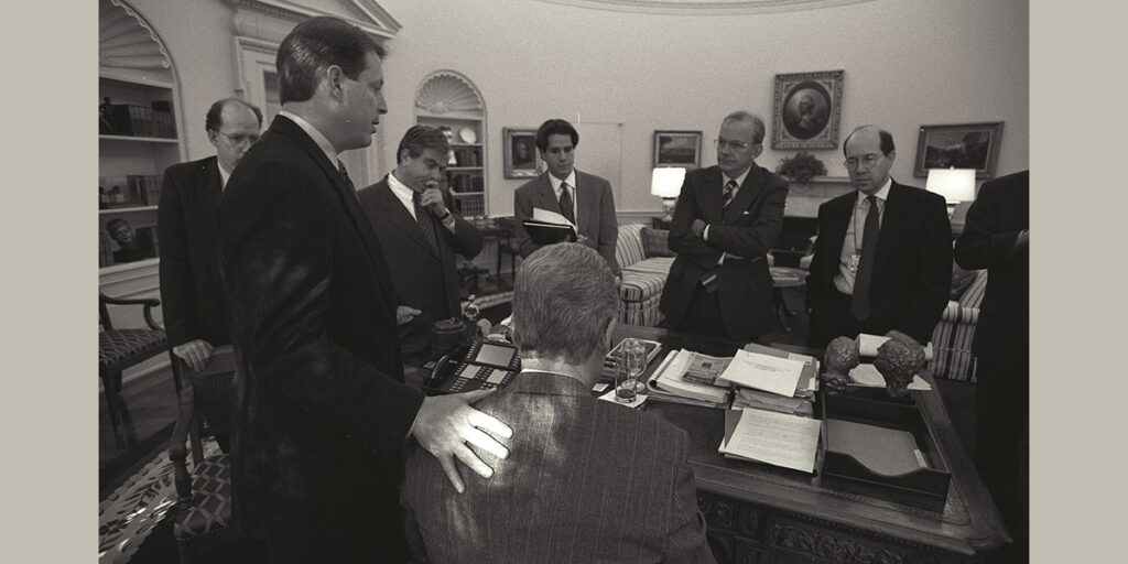 Bill Clinton amerikai elnök (háttal ül) munkatársai körében megbeszéli a daytoni megállapodás bejelentéséről szóló beszédét. Balról az első Strobe Talbott külügyminiszter-helyettes, akinek a házában a koncepció megszületett, a második pedig Al Gore alelnök. Jobbról a második Anthony Lake nemzetbiztonsági tanácsadó, aki Talbott-tal együtt dolgozta ki a béketárgyalás amerikai platformját. Richard Holbrooke, aki az egészet letárgyalta, aznap is Daytonban tartózkodott. (Fotó: Fehér Ház sajtószolgálata)