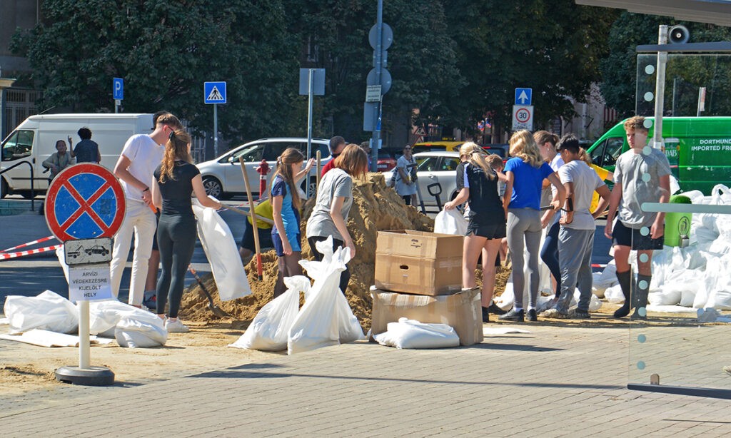 Önkéntes diákok homokzsákokat töltenek a gáton