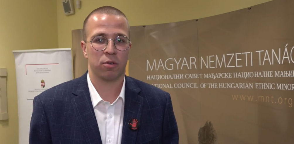 Véres kezet ábrázoló kitűzővel állt a Pannon kamerája elé az MNT rendezvényén